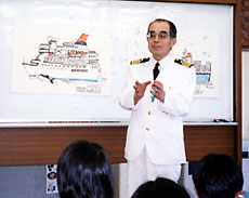 こどもたちに絵を描きながら海と船の話をする名誉船長（2002年6月）